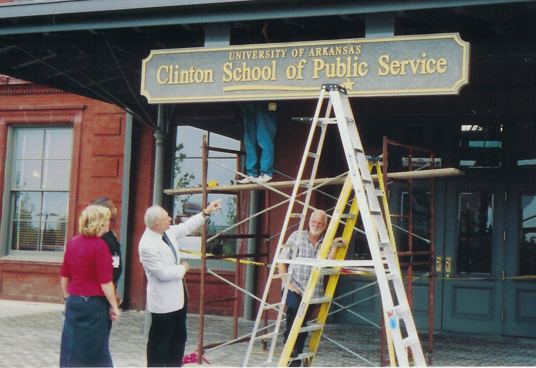 David Pryor hanging Clinton School sign at Sturgis Hall.